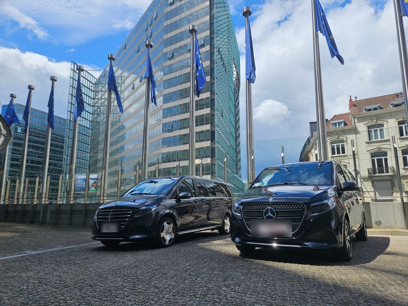 Two FFGR Belgium Mercedes V-Class beneath the European flags in the Brussels European Quarter